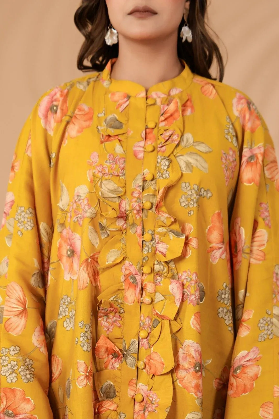 Yellow floral blouse worn by a person against a beige background-YAVASTRAH