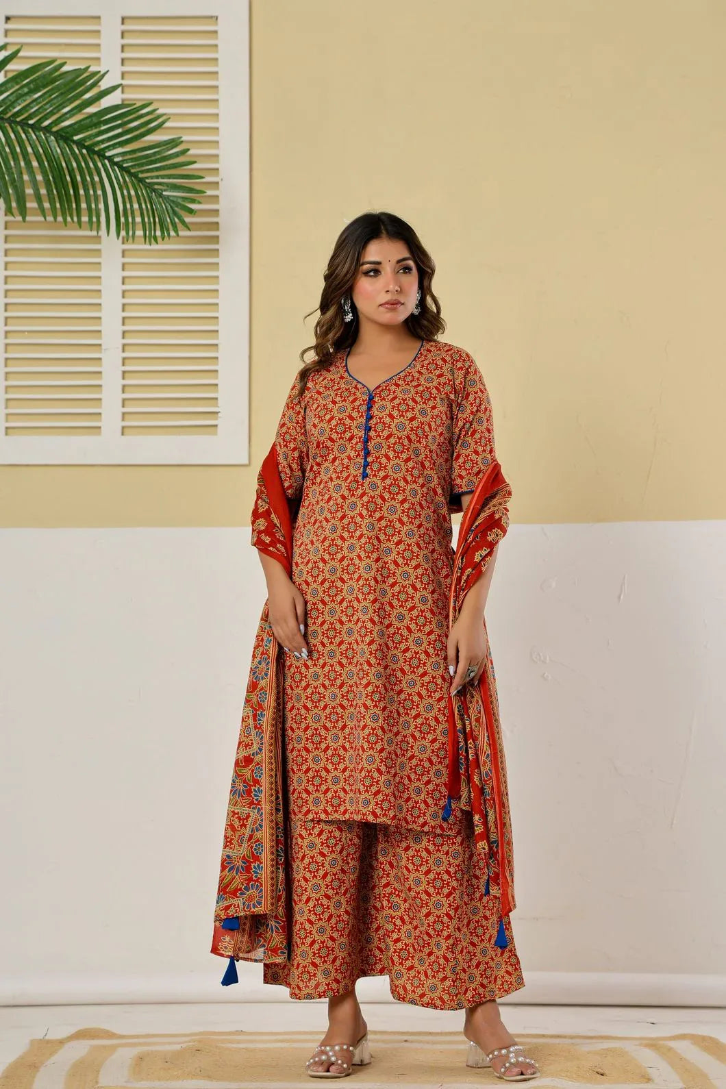 Woman wearing red kurta palazzo set styled with traditional accessories full view - YAVASTRAH

