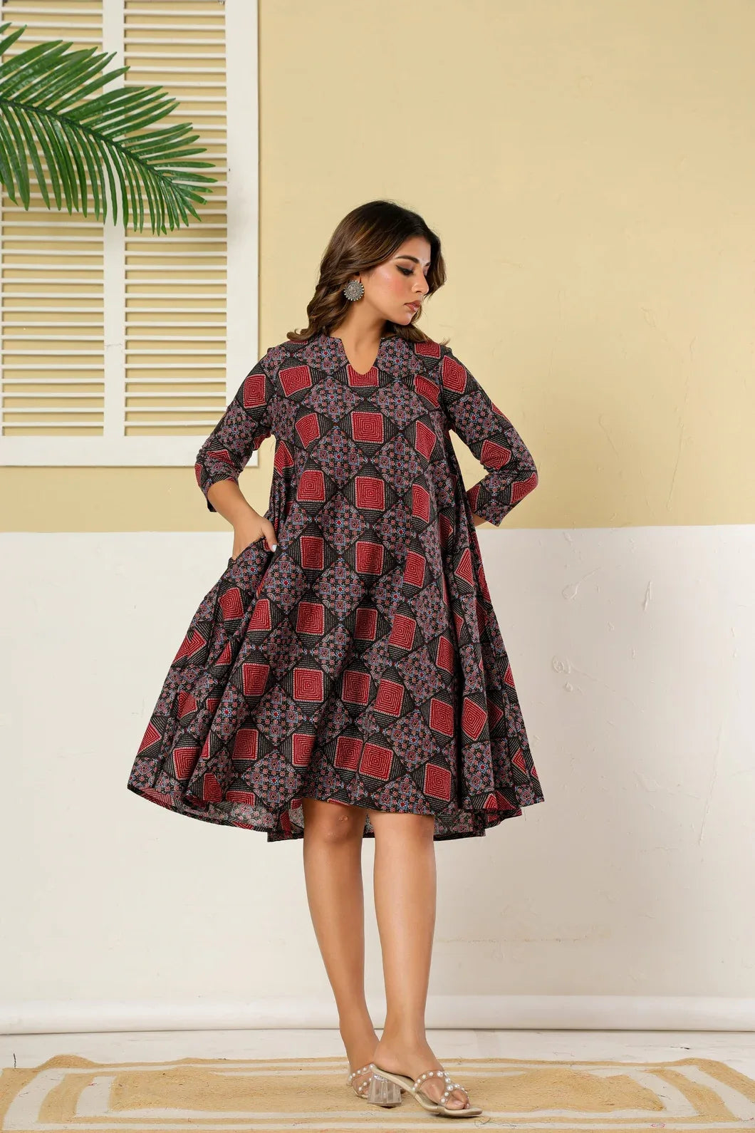 Woman in maroon black flare dress, close-up of neckline and print - YAVASTRAH
