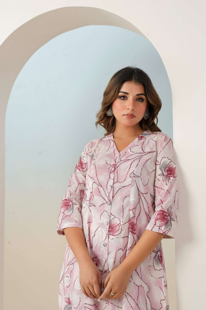 Woman wearing a floral dress standing in front of an archway with a gradient background