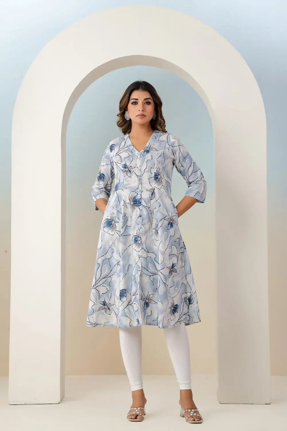 Woman wearing a floral dress standing in front of an archway