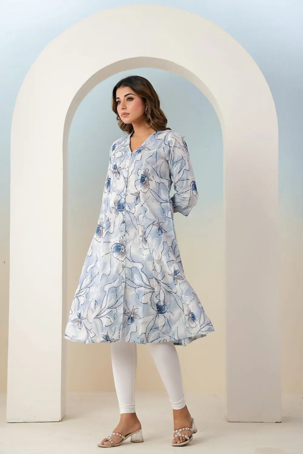 Woman wearing a floral dress standing in front of an archway