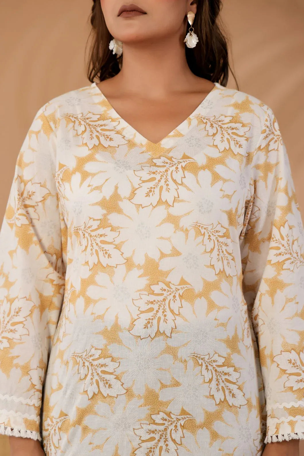 Woman wearing ivory and mustard floral kurti styled with traditional accessories - YAVASTRAH
