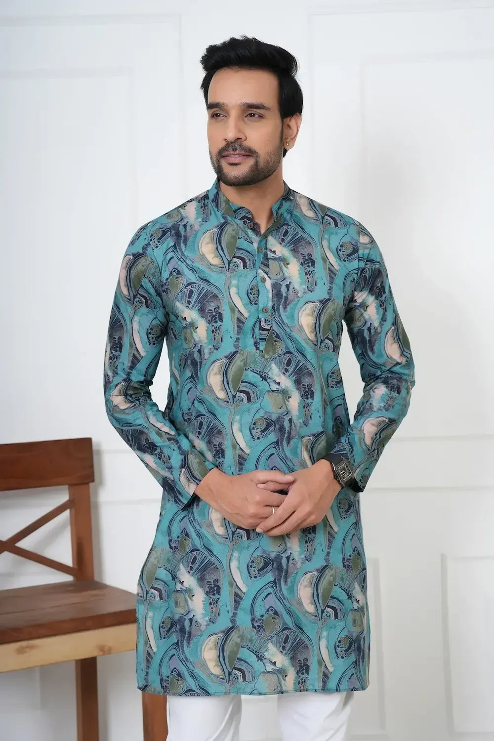 Man wearing a blue patterned kurta against a white background